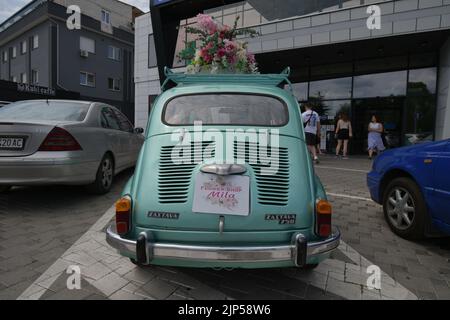 Der legendäre Auto-Supermini Zastava 750 (Fiat 600), der von 1955 bis 1985 produziert wurde, parkte vor dem Blumengeschäft, geschmückt mit Blumen Stockfoto