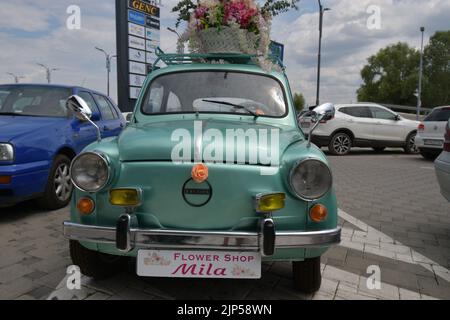 Der legendäre Auto-Supermini Zastava 750 (Fiat 600), der von 1955 bis 1985 produziert wurde, parkte vor dem Blumengeschäft, geschmückt mit Blumen Stockfoto