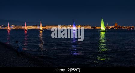 Russland, St. Petersburg, 07. August 2022: Ein paar Segelboote mit Segeln beleuchtet in der Trikolore Russlands gehen in die Innenstadt zur Feier der Stockfoto