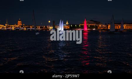 Russland, St. Petersburg, 07. August 2022: Ein paar Segelboote mit Segeln beleuchtet in der Trikolore Russlands gehen in die Innenstadt zur Feier der Stockfoto