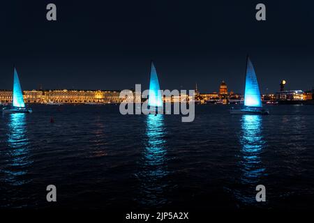 Russland, St. Petersburg, 07. August 2022: Ein paar Segelboote mit Segeln beleuchtet in der Trikolore Russlands gehen in die Innenstadt zur Feier der Stockfoto