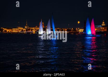 Russland, St. Petersburg, 07. August 2022: Ein paar Segelboote mit Segeln beleuchtet in der Trikolore Russlands gehen in die Innenstadt zur Feier der Stockfoto