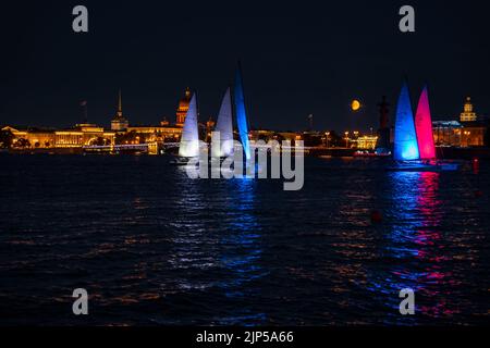 Russland, St. Petersburg, 07. August 2022: Ein paar Segelboote mit Segeln beleuchtet in der Trikolore Russlands gehen in die Innenstadt zur Feier der Stockfoto