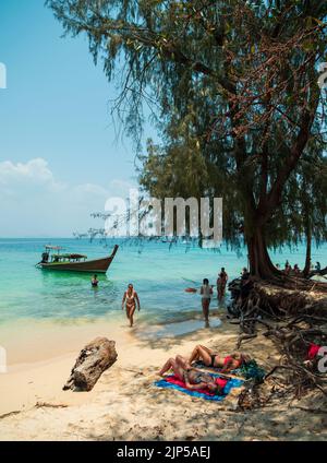 Strand auf der Insel Koh Kradan in der Andamanensee. Traditionelle thailändische Boote und Touristen, die auf der paradiesischen Insel kreuzen und schwimmen Stockfoto