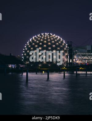 Eine vertikale Aufnahme des Toronto Seeufers und des Ontario Place bei Nacht Stockfoto