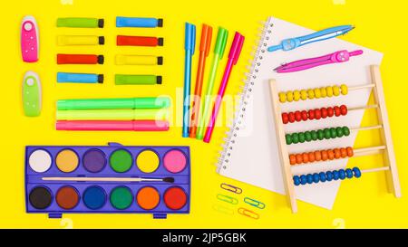 Lebhaft gelber Hintergrund mit Back to School Schreibwaren Anordnung. Flach liegend Stockfoto