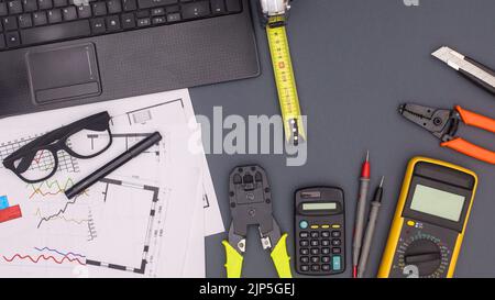 Business- und Architekturtisch mit Plänen und Bauwerkzeugen. Flach liegend Stockfoto