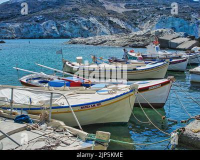 Ein kleiner Hafen mit Fischerbooten und kristallklarem türkisfarbenem Wasser im Dorf Mandrakia auf der Insel Milos, Griechenland Stockfoto