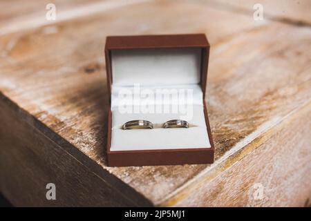 Zwei Eheringe in einer Kiste am Tischrand. Stockfoto
