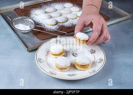 Konditor nimmt eine Hochzeit süßen Leckerbissen mit bestreuten Zucker und dulce de leche Füllung. Stockfoto