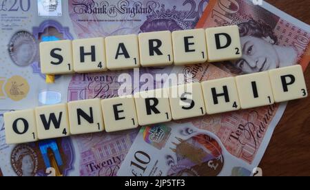 UK Property Shared Ownership, geschrieben in Scrabble Letters, auf Geldscheinen Stockfoto