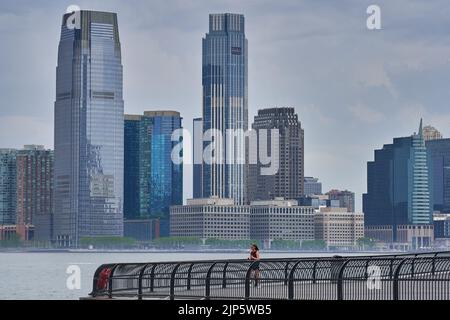 Ein schöner Blick auf die Gebäude in Manhattan im Hintergrund des Meeres an einem Sommernachmittag Stockfoto