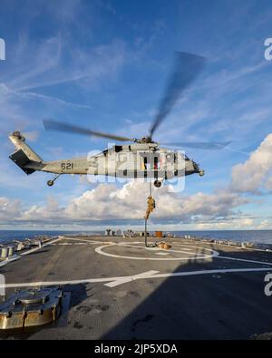 PHILIPPINISCHES MEER (Aug 4, 2022) ein Techniker für die Sprengstoffentsorgung (EOD), der EOD Mobile Unit 5 Schnellseilen von einem MH-60s Sea Hawk, der an das Helicopter Sea Combat Squadron (HSC) 15 angeschlossen ist, auf das Flugdeck an Bord des Arleigh Burke-Klasse-Lenkraketen-Zerstörers USS Higgins (DDG 76) zugewiesen wurde, während er Operationen im philippinischen Meer durchführte, August 4. Higgins wird der Task Force 71/Destroyer Squadron (DESRON) 15 zugewiesen, der größten vorwärtseingesetzten DESRON der Marine und der wichtigsten Oberflächenkraft der US-Flotte von 7.. (USA Navy Foto von Mass Communication Specialist 1. Class Donavan K. Patubo) Stockfoto