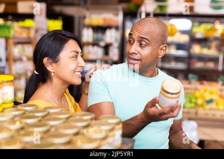 Ehepaar, das sich für Konserven im Supermarkt entschieden hat Stockfoto