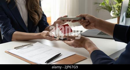 Immobilienmakler und Immobilieninvestoren tauschen sich mit Investoren aus, die Geld in die Hand der Agenten legen. Stockfoto