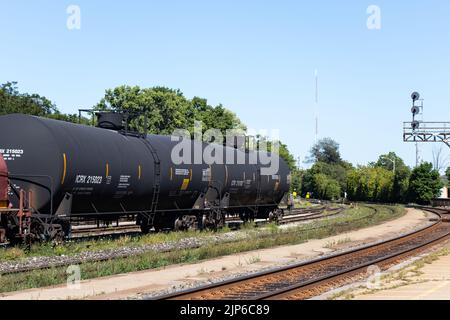 Drei Öltanker-Güterzugwagen werden zusammen gesehen, die tagsüber auf einem Eisenbahnhof stehen. Stockfoto