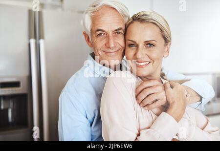 Mehr verliebt als je zuvor. Beschnittenes Porträt eines liebevollen reifen Paares in ihrem Zuhause. Stockfoto