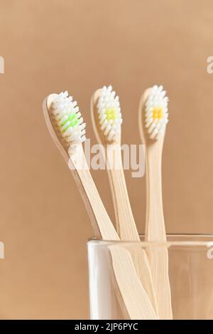 Set aus drei ökologischen Bambus-Zahnbürsten in einer Glasschale. Konzepte: Nachhaltiger Lebensstil, Verwendung kompostierbarer und umweltfreundlicher Materialien Stockfoto