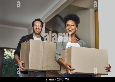 Neues Haus, Umzug und glückliches Paar mit Kisten, während das Gefühl stolz und aufgeregt über den Kauf eines Hauses mit einem Hypothekendarlehen. Interracial Ehemann und Stockfoto