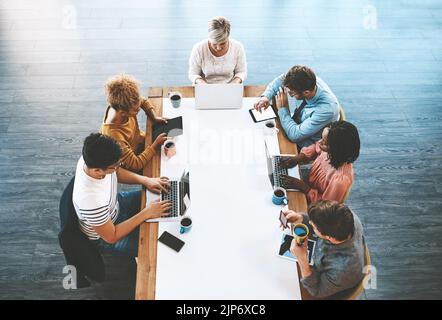 Kollegen planen, diskutieren Strategien und suchen online. Verschiedene Geschäftsleute, die sich in Meetings unterhalten, auf Laptops tippen und auf einem Tablet surfen Stockfoto