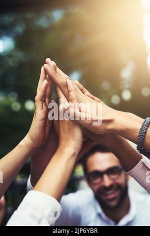 Hoch fünf zu unserem nächsten großen Erfolg. Eine Gruppe von Kollegen hoch fiving im Freien. Stockfoto