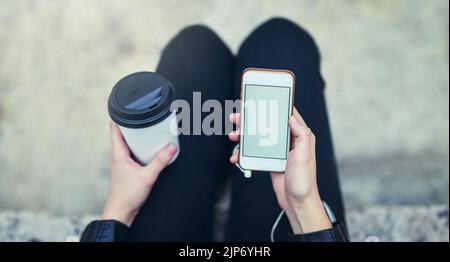 Eine der bequemsten Möglichkeiten der Kommunikation. Eine Frau, die ein Mobiltelefon in der Stadt benutzt. Stockfoto