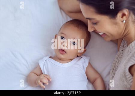 Mütter wie ein Engel, weil sie über mich wacht. High-Angle-Aufnahme einer jungen Frau, die sich zu Hause mit ihrem kleinen Jungen verklebt. Stockfoto