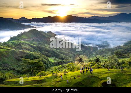 Die Touristen freuen sich, den Sonnenaufgang und das mit weißen Wolken gefüllte Tal in der Tak Po-Bergkette in Na zu beobachten Stockfoto