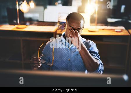 Er kann einfach nicht schütteln den Stress. Ein hübscher junger Geschäftsmann erleben Stress während der späten Nacht bei der Arbeit. Stockfoto