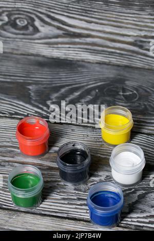 Gouache-Set. Farbdosen öffnen. Auf Kiefernbrettern. Nahaufnahme. Stockfoto