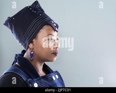 Stark sein schön sein. Studioporträt einer selbstbewussten Frau mittleren Alters, die auf die Kamera schaut, während sie vor einem grauen Hintergrund steht. Stockfoto