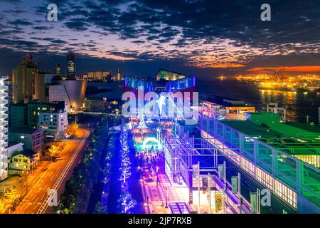 Osaka, Japan - 27. November 2018: Luftaufnahme über die Gebäude des Kaiyukan Aquariums, geschmückt mit bunten Lichtern, mit Touristen, die nachts herumlaufen. Stockfoto