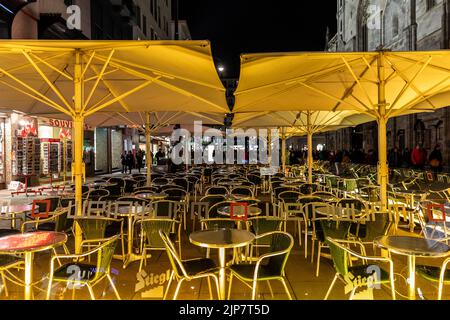Wien, Österreich - 29. Oktober 2019: Tische und Stühle unter den Sonnenschirmen des Außenrestaurants mit Hintergrund vieler Touristen, die herumlaufen. Stockfoto
