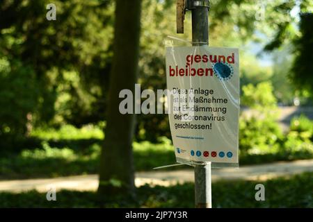 Ein Stay Healthy Sign mit Covied-19 mit Hinweisen und Regeln in einem Park Stockfoto