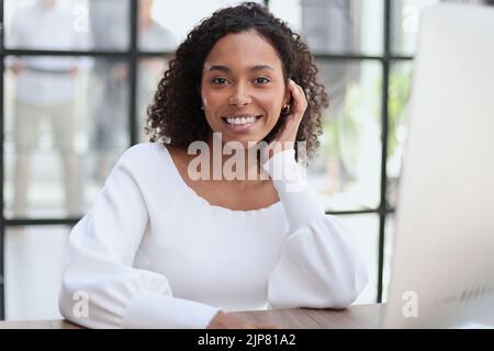 Porträt einer selbstbewussten Geschäftsfrau mit Team im Hintergrund Stockfoto