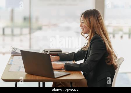 Schöne junge asiatische Geschäftsfrau im Büro Stockfoto