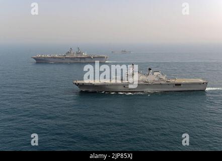 Das südkoreanische amphibische Angriffsschiff ROKS Dokdo (LPH 6111), vorne, durchschifft während einer Fotoübung mit anderen Schiffen, die 140327 zugewiesen wurden, neben dem amphibischen Angriffsschiff USS Bonhomme Richard (LHD 6) Stockfoto