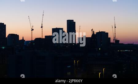 Skyline von Leeds City, West Yorkshire bei einem Sommersonnenaufgang mit dem Altus House und den umliegenden Gebäuden und Kränen Stockfoto