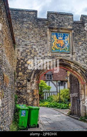 Stadtmauer und grüne Mülltonnen. Altes Stadttor, in der Nähe von Kings Gate, Winchester, Großbritannien Stockfoto