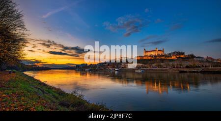 Sonnenuntergang über der Burg Bratislava, dem slowakischen parlament und der Donau in der Slowakei Stockfoto