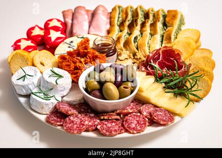 Mittagessen oder Vorspeise mit einem einzigen Gericht aus Salami, Pepperoni, Brie-Käse, Schinken. Essteller oder Vorspeise mit Salumi, Käse und Focaccia-Brot Stockfoto