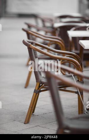 Die leeren Holzstühle mit Tischen in einem Café im Freien Stockfoto
