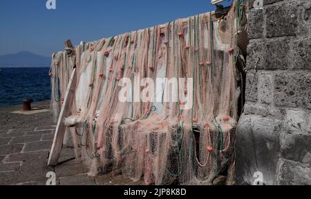 Im Dorfhafen von Marina Grande in Sorrent Italien hängen Fischernetze traditioneller Fischer zum Trocknen aus. Eine beliebte Gegend für Fischrestaurants. Stockfoto