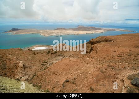 Salinas del Río im Vordergrund mit Isla de La Graciosa im Hintergrund Stockfoto