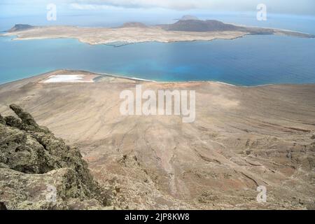 Salinas del Río im Vordergrund mit Isla de La Graciosa im Hintergrund Stockfoto