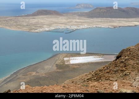 Salinas del Río im Vordergrund mit Isla de La Graciosa im Hintergrund Stockfoto