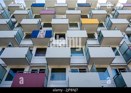 München, Deutschland. 16. August 2022. Die Balkone an der Fassade eines Wohnhauses sind teilweise mit farbenfroher Verkleidung bedeckt. Kredit: Peter Kneffel/dpa/Alamy Live Nachrichten Stockfoto