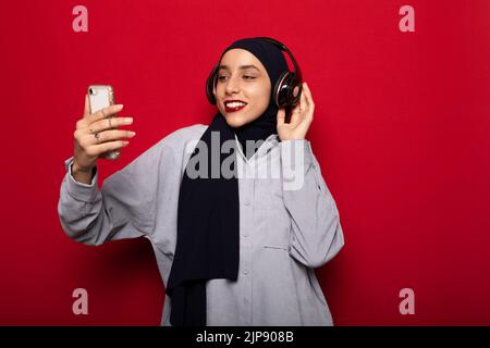 Mobile Kommunikation, muslim, Musik hören, Hijab, mobile Kommunikation, muslime, Musikhören, Hijabs Stockfoto