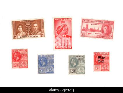 Eine Auswahl alter Münzpostmarken aus Britisch-Guayana auf weißem Hintergrund. Stockfoto