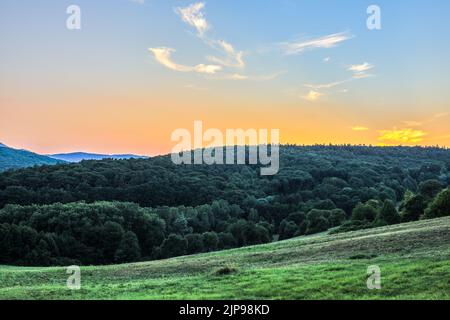 Mischwald nach Sonnenuntergang. Sommerabendlandschaft mit buntem Himmel, feurigen Klumpen. Natürlicher Hintergrund, Tapete. Hrabowka, Slowakei Stockfoto